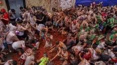 Orang-orang yang bersuka ria saling melempar tomat selama pesta pertarungan tomat tahunan "Tomatina", di desa Bunol dekat Valencia, Spanyol, Rabu (28/8/2024).  (AP Photo/Alberto Saiz)