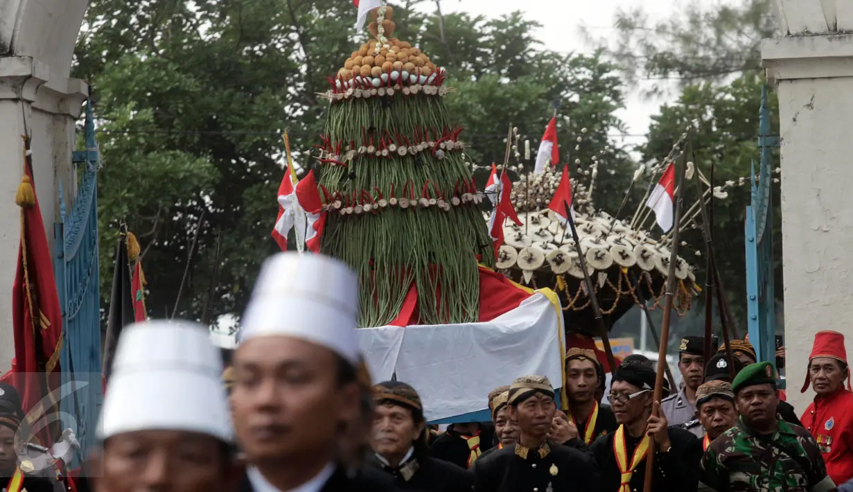 Para abdi dalem Keraton membawa sesaji gunungan pada acara Grebeg Syawal di halaman Masjid Agung Solo, Jawa Tengah, Jumat (8/7). Grebeg Syawal merupakan tradisi Keraton Kasunanan Surakarta untuk merayakan Idul Fitri. (Liputan6.com/Boy Harjanto)