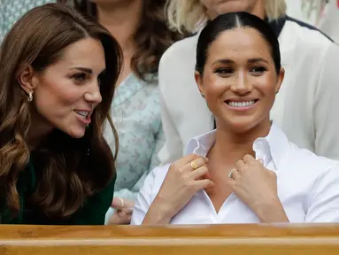 Duchess of Cambridge Kate Middleton (kiri) dan Duchess of Sussex Meghan Markle berbincang saat menyaksikan pertandingan final tunggal putri Wimbledon 2019 antara Serena Williams dengan Simona Halep di All England Lawn Tennis and Croquet Club, London, Inggris, Sabtu (13/7/2019). (BEN CURTIS/POOL/AFP)