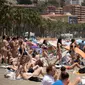 Sejumlah turis memenuhi pinggir pantai di Malaga, Spanyol, untuk berjemur. (dok. JORGE GUERRERO / AFP)