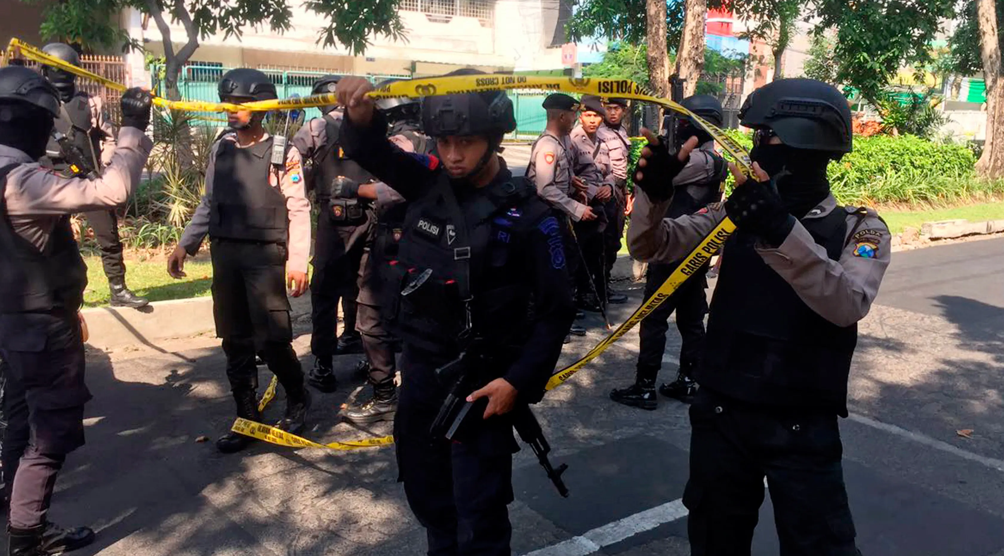 Petugas memasang garis polisi dekat lokasi ledakan bom di Gereja Santa Maria, Surabaya, Minggu (13/5). Polisi Selain di Gereja Katolik Santa Maria, dua ledakan lain di Gereja Pantekosta Pusat Surabaya dan Gereja Kristen Jawi Wetan. (AP/Trisnadi)