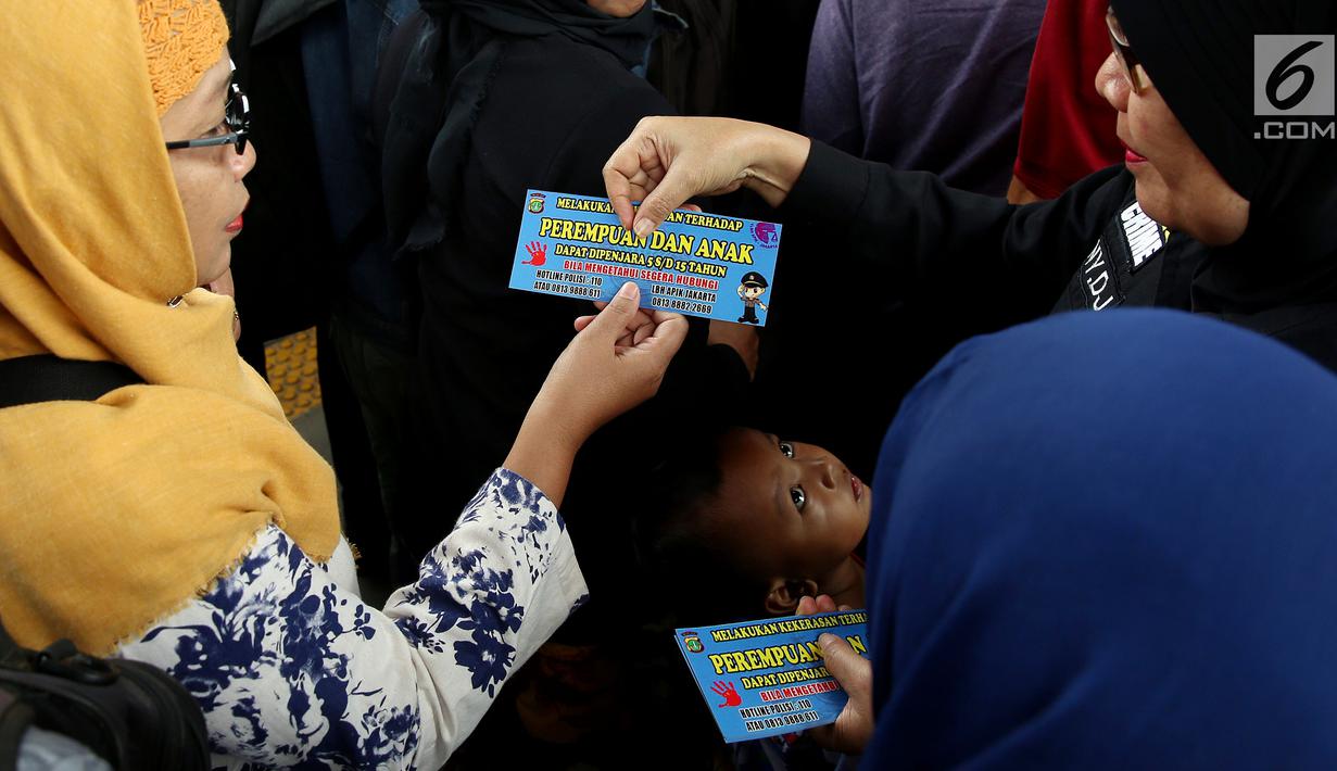 Petugas dari Polda Metro Jaya membagikan stiker kepada pengguna Kereta di Stasiun Tanah Abang, Jakarta, Kamis (21/12). Stiker ini bertuliskan informasi tentang pengaduan ketika terjadi kasus pelecehan seksual di ruang publik. (Liputan6.com/JohanTallo)