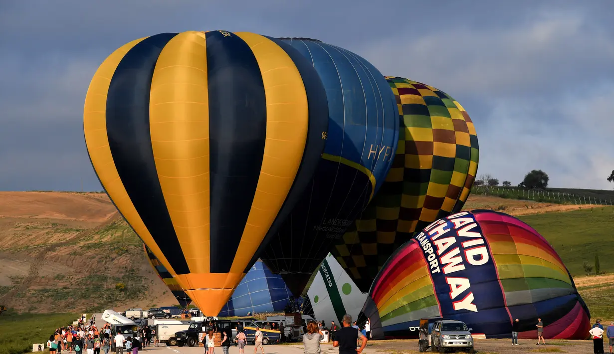 Orang-orang melihat persiapan balon udara pada festival internasional Sagrantino di kawasan Umbria, Italia, 22 Juli 2018. Puluhan balon udara berkompetisi menghadapi tantangan dalam festival yang memperebutkan piala perak tersebut (AFP PHOTO/TIZIANA FABI)