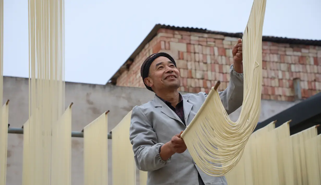 Penduduk desa mengeringkan mi di Desa Huangjiazhuang di Distrik Maiji, Kota Tianshui, Provinsi Gansu, China pada 30 November 2020. Mi buatan desa itu tidak hanya populer di kalangan penduduk setempat, tetapi juga laris terjual ke seluruh penjuru China melalui platform e-commerce. (Xinhua/Ma Xiping)