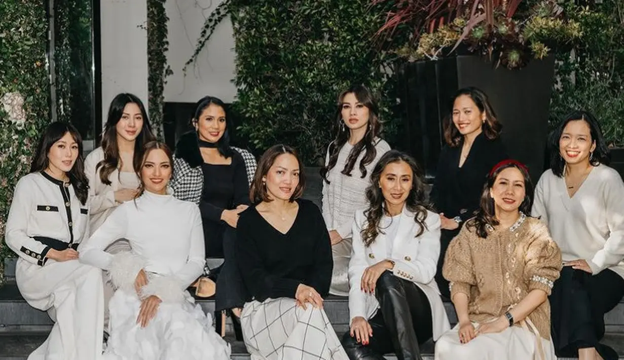 Nia Ramadhani saat berfoto bersama saudara perempuannya, tampil stunning mengenakan atasan halter neck putih lengan panjang dengan aksen bulu dipadukan rok panjang motif 3D dipadukan heels silver.  [@ramadhaniabakrie]