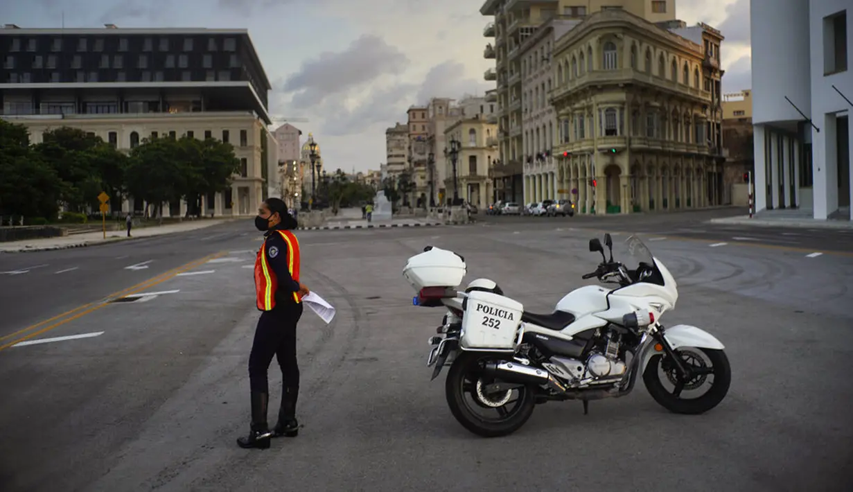 Polisi yang mengenakan masker berjaga di jalanan saat penerapan jam malam di Havana, Kuba, Selasa (1/9/2020). Otoritas Kuba menerapkan lockdown selama 15 hari di Havana untuk keluar dari penularan COVID-19 tingkat rendah tetapi terus-menerus. (AP Photo/Ramon Espinosa)