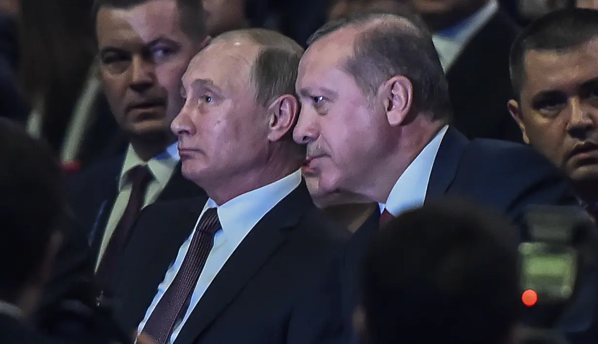 Presiden Turki Recep Tayyip Erdogan berbincang dengan Presiden Rusia Vladimir Putin saat menghadiri 23rd World Energy Conress, Istanbul, Turki (10/10). Putin dan Erdogan akan melakukan normalisasi hubungan negara yang sempat tegang. (AFP PHOTO/Ozan Kose)