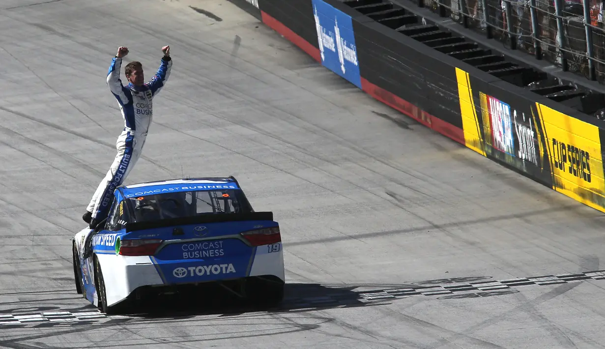 Pembalap dari Comcast Business Toyota, Carl Edwards berdiri di pintu mobil saat merayakan kemenangan NASCAR Sprint Cup Series Food City 500 di Bristol Motor Speedway (17/4). (AFP/Matt Sullivan)