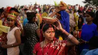 Perempuan Hindu India membawa pot tanah di kepalanya selama ritual Dewi Durga di sungai Yamuna di hari terakhir festival, New Delhi, India (11/10). Ditenggelamkannya patung ini menandai berakhirnya festival Durga Puja. (AP Photo/Altaf Qadri)