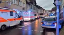 Kendaraan polisi dan ambulans berada di lokasi bus sekolah menabrak tembok sebuah toko di Eberbach dekat Mannheim, Jerman, Selasa (16/1). Tiga helikopter dikerahkan untuk menyelamatkan korban dan membawanya mereka ke rumah sakit. (Rene Priebe/dpa/AFP)