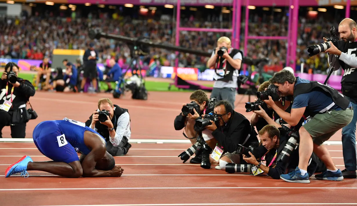 Sejumlah fotografer mengabadikan atlet asal Amerika Serikat, Justin Gatlin setelah memenangi final acara atletik 100m putra di Kejuaraan Dunia IAAF 2017 di Stadion London di London, Inggris (5/8). (AFP Photo/Ben Stansall)