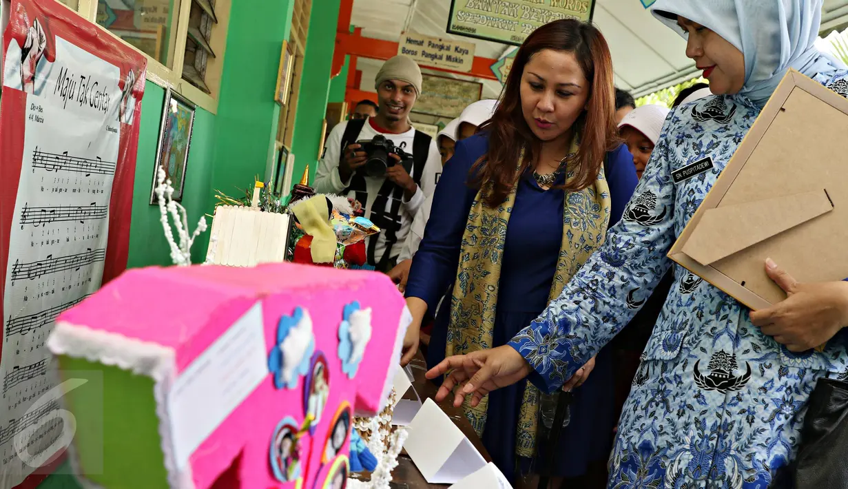 Guru memperlihatkan karya anak didiknya saat kunjungan Tim Petualangan Agen Penny, Jakarta, Selasa (10/11/2015). Program tersebut bertujuan untuk meningkatkan literasi keuangan bagi anak-anak usia Sekolah Dasar. (Liputan6.com/Immanuel Antonius)