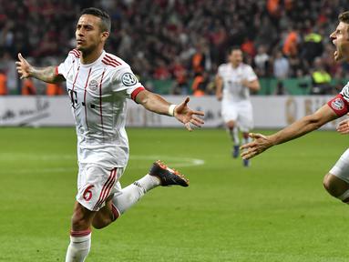 Gelandang Bayern Munchen, Thiago Alcantara, melakukan selebrasi usai mencetak gol ke gawang Bayer Leverkusen pada laga DFB Pokal di Stadion BayArena, Selasa (17/4/2018). Bayern Munchen menang 6-2 atas Bayer Leverkusen. (AP/Martin Meissner)