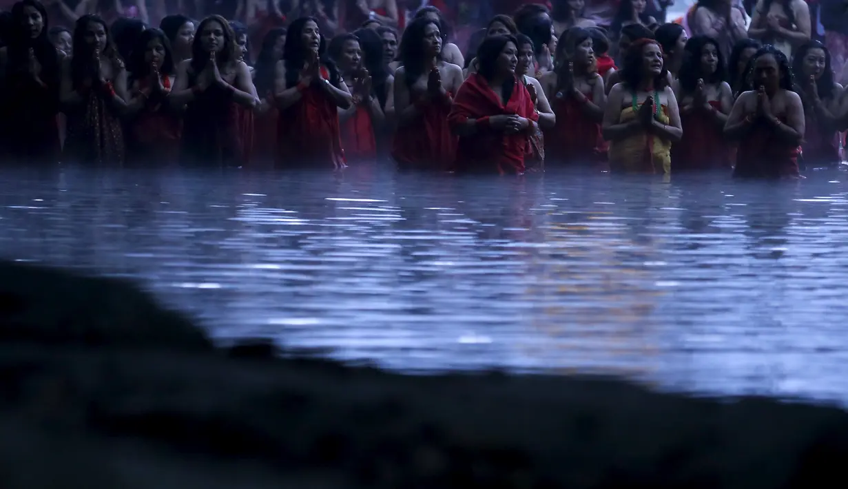 Sejumlah wanita Hindu Nepal saat mandi suci di Sungai Salinadi pada Festival Swasthani Brata Katha di Katmandu, Nepal, (24/1). Selama festival ini, para wanita yang belum menikah berdoa untuk mendapatkan suami yang baik. (REUTERS/Navesh Chitrakar)