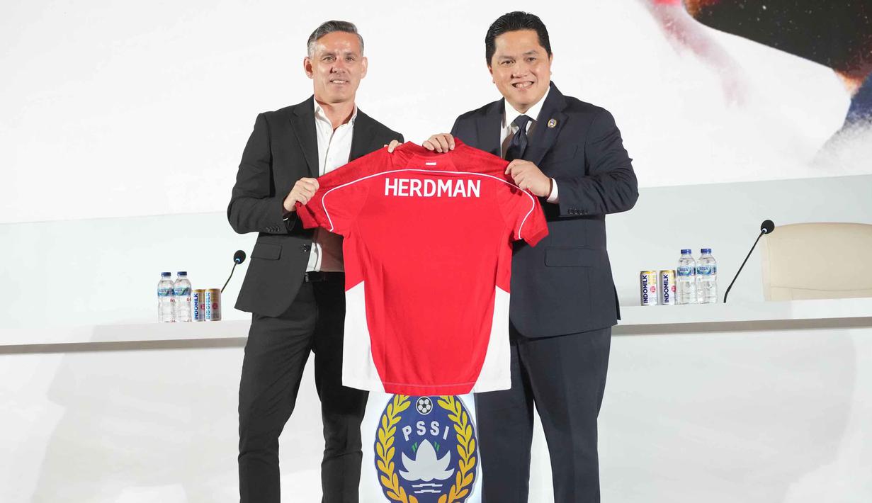 Pengangkatan Herdman sebelumnya telah lebih dulu diumumkan melalui media sosial federasi pada 3 Januari 2026 silam. Tampak dalam foto, Pelatih kepala baru tim nasional sepak bola Indonesia, John Herdman (kiri), dan Ketua Persatuan Sepak Bola Seluruh Indonesia (PSSI), Erick Thohir memegang jersey saat konferensi pers di Jakarta, Selasa 13 Januari 2026. (AP Photo/Achmad Ibrahim)