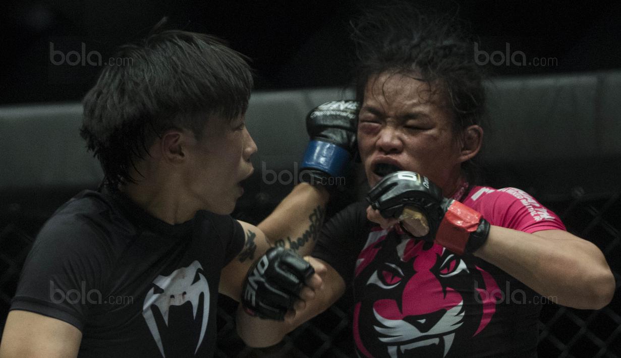 Petarung Cina, Xiong Jing Nan, memukul petarung Singapura, Tiffany Teo, saat laga One Championship di JCC Senayan, Jakarta, Sabtu (20/1/2018). Jing Nan berhasil merebut juara dunia kelas jerami. (Bola.com/Vitalis Yogi Trisna)
