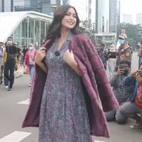 Artis Jessica Iskandar berlenggak-lenggok di zebra cross Dukuh Atas saat meramaikan Citayam Fashion Week di kawasan SCBD (Sudirman Citayam Bojong Gede Dukuh Atas), Dukuh Atas, Jakarta Pusat, Senin (25/7/2022). Jessica Iskandar tampak anggun mengenakan gaun bunga-bunga dengan luaran blazer bewarna ungu. (Liputan6.com/Herman Zakharia)