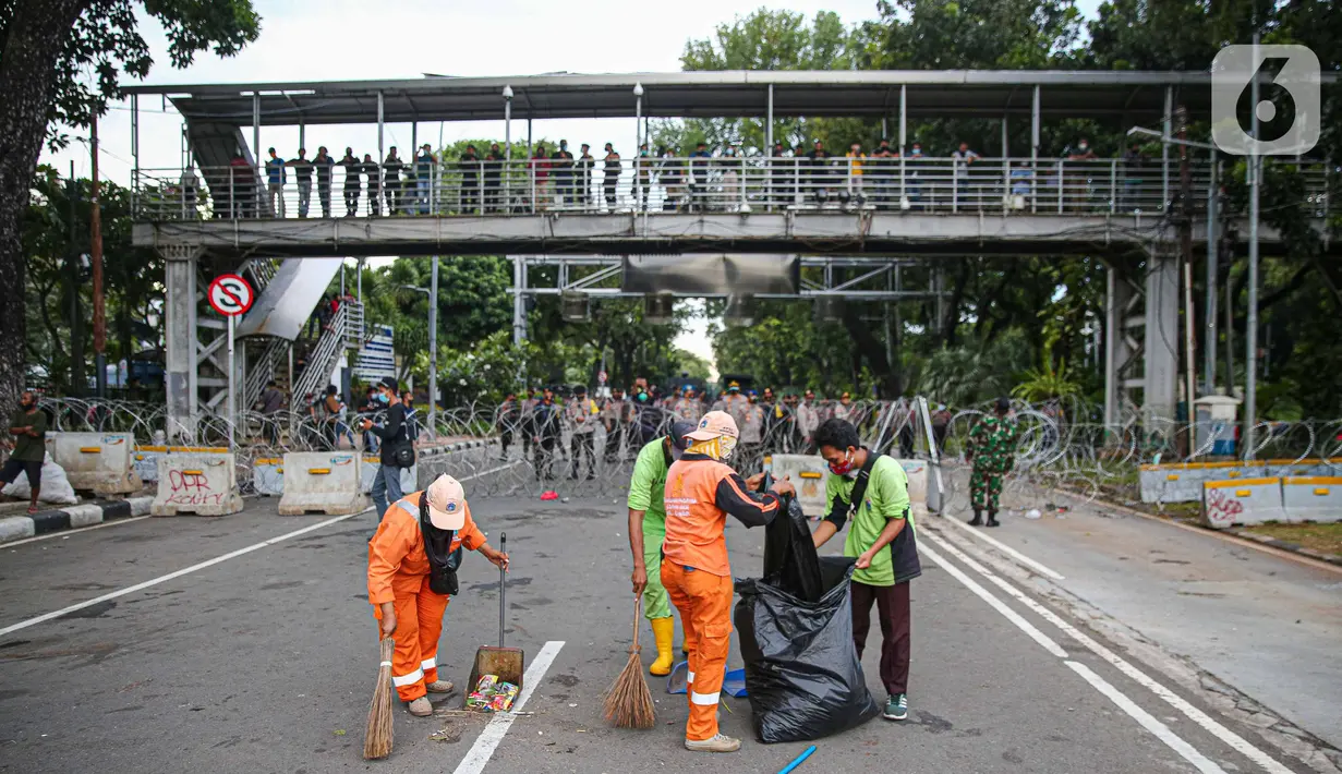 Petugas kebersihan membersihkan sampah sisa pendemo usai unjuk rasa buruh di kawasan Patung Kuda, Jakarta, Kamis (22/10/2020). Sebelumnya, buruh dari berbagai elemen berunjuk rasa menolak pengesahan Omnibus Law UU Cipta Kerja. (Liputan6.com/Faizal Fanani)