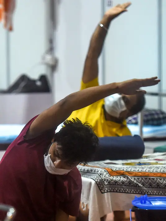 Pasien melakukan yoga di dalam bangsal di kompleks olahraga Commonwealth Games (CWG) Village yang sementara diubah menjadi pusat perawatan Covid-19 di New Delhi, India, Kamis (16/7/2020). Kasus virus corona (Covid-19) di India hampir menyentuh angka 1 juta orang.  (Money SHARMA / AFP)