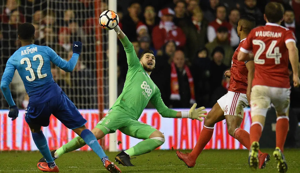 Kiper Nottingham Forest, Jordan Smith, menghalau bola yang mengarah ke gawangnya saat pertandingan melawan Arsenal pada laga Piala FA di Stadion City Ground, Minggu (7/1/2018). Arsenal takluk 2-4 dari Nottingham Forest. (AFP/Oli Scarff)