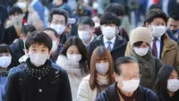 Orang-orang yang memakai masker wajah melakukan tradisi doa untuk Tahun Baru pada hari kerja pertama tahun ini di Kuil Kanda Myojin, di Tokyo, Jepang, Senin (4/1/2021).  Masyarakat Jepang berdoa bersama di kuil tersebut untuk memohon kelancaran bisnis. (AP Photo/Koji Sasahara)