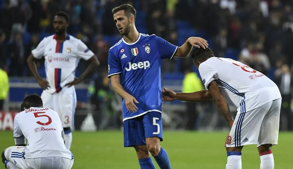 Pemain Juventus, Miralem Pjanic, berusaha menghibur pemain Olympique Lyon seusai laga Grup H Liga Champions di Stade de Lyon, Prancis, Rabu (19/10/2016) dini hari WIB. (AFP/Philippe Desmazes)