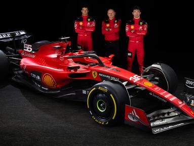 Pebalap Scuderia Ferrari Carlos Sainz Jr (kiri) dan Charles Leclerc bersama Team principal Frederic Vasseur (tengah) berpose di samping mobil baru Ferrari SF-23 untuk Formula 1 2023 di Maranello 14 Februari 2023. (AFP/Ferrari Press Office)