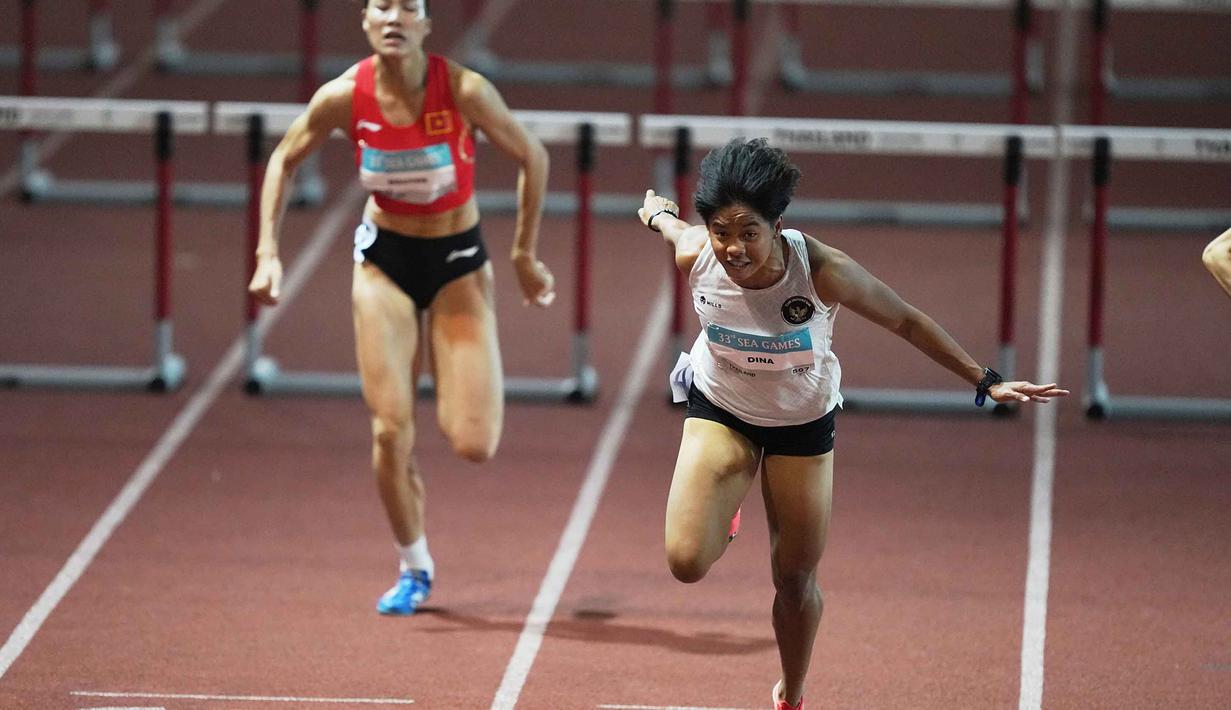 Ia merupakan pemegang rekor nasional dengan torehan waktu 13,11 detik yang dicetak pada Kejuaraan Asia ke-26 di Gumi Stadium, Korea Selatan, Mei 2025 lalu. Tampak dalam foto, Atlet lari gawang putri Indonesia, Dina Aulia (kanan) saat berkompetisi di final lari gawang 100 meter putri pada SEA Games ke-33 di Bangkok, Thailand, Jumat 12 Desember 2025. (AP Photo/ Achmad Ibrahim)