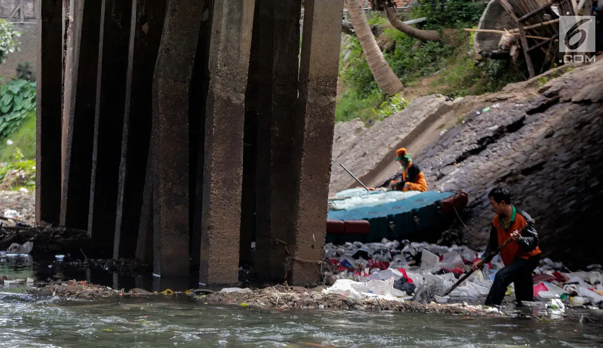 Petugas PPSU saat membersihkan tumpukan sampah yang tersangkut  di aliran anak kali Ciliwung, Jakarta, Senin (22/7/2019). Pembersihan sungai dari berbagai sampah tersebut dimaksudkan agar tidak ada penumpukan sampah dan sedimentasi saluran di sepanjang sungai. (Liputan6.com/Faizal Fanani)
