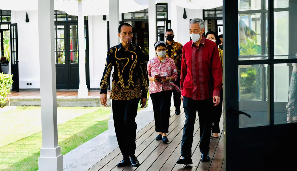Setelah menyampaikan pernyataan pers bersama dan sebelum melakukan jamuan santap siang, Presiden Joko Widodo (kiri) dan PM Singapura Lee Hsien Loong berjalan bersama di The Shancaya Resort Bintan, Bintan, Kepulauan Riau, Selasa (25/1/2022). (Laily Rachev/Biro Pers Setpres)