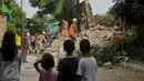 Warga dibantu petugas mengevakuasi sebuah mobil minibus di permukiman RT 08/10, Duri Pulo, Jakarta,  Senin (13/6). Tembok setinggi empat meter roboh menimpa sebuh mobil mini bus di bawahnya. (Liputan6.com/Gempur M Surya)