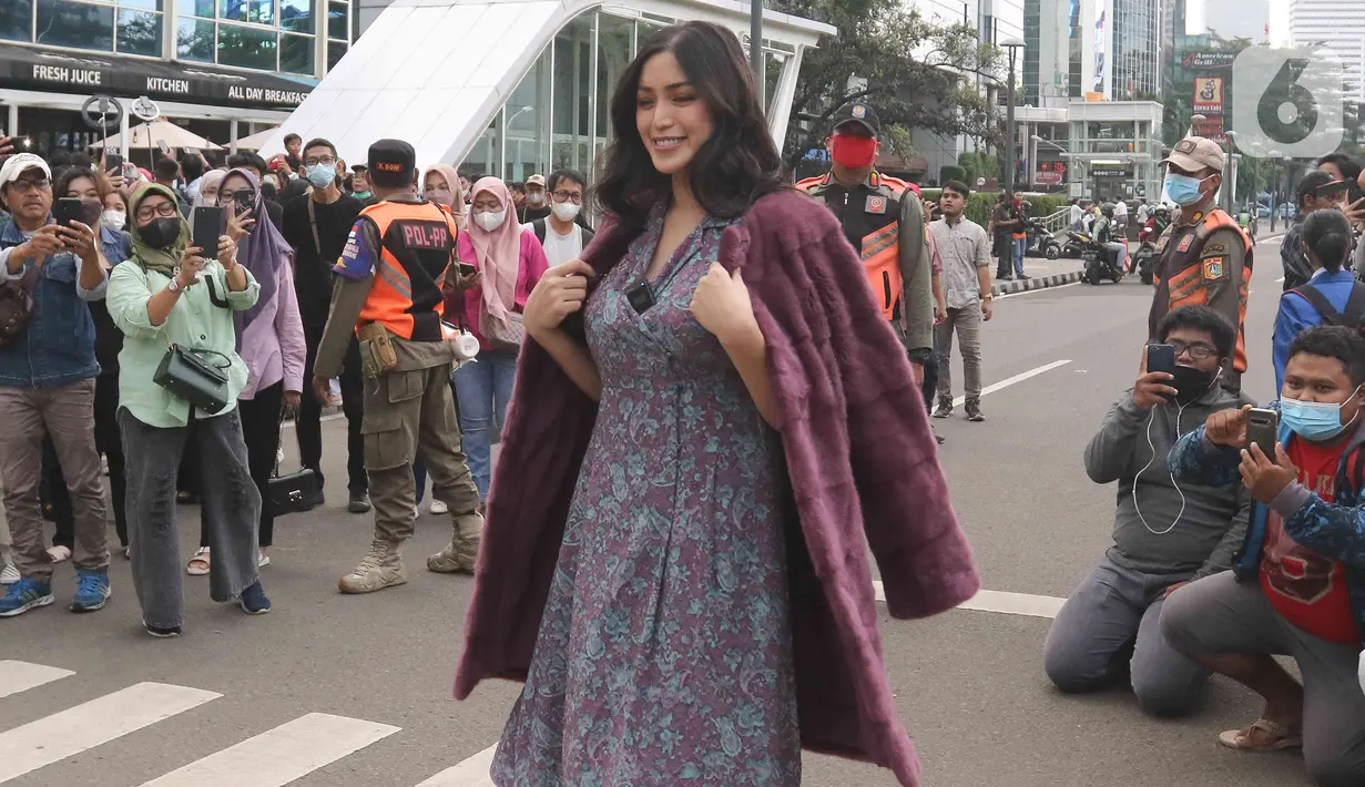 Artis Jessica Iskandar berlenggak-lenggok di zebra cross Dukuh Atas saat meramaikan Citayam Fashion Week di kawasan SCBD (Sudirman Citayam Bojong Gede Dukuh Atas), Dukuh Atas, Jakarta Pusat, Senin (25/7/2022). Jessica Iskandar tampak anggun mengenakan gaun bunga-bunga dengan luaran blazer bewarna ungu. (Liputan6.com/Herman Zakharia)