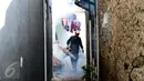 Petugas menyusuri salah satu gang di kawasan Menteng Atas dan Menteng Tenggulun untuk melakukan pengasapan, Jakarta, Senin (8/5). Penyemprotan asap dilakukan untuk mencegah perkembangbiakan nyamuk demam berdarah. (Liputan6.com/Helmi Fithriansyah)