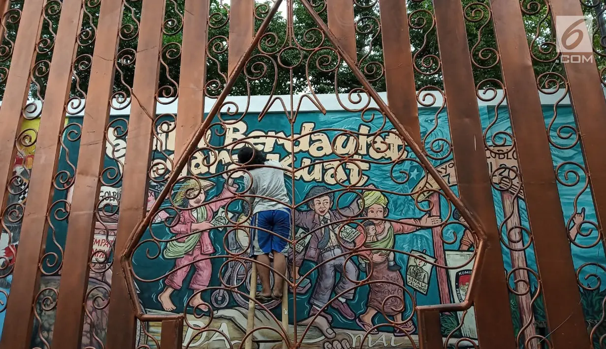 Seorang pria menyelesaikan pembuatan lukisan mural di Kawasan TBRS Semarang, Minggu, (3/3). Acara yang diadakan oleh KPU Jateng ini adalah sosialisasi ajakan mencoblos pemilu saat april mendatang. (Liputan6.com/Gholib)