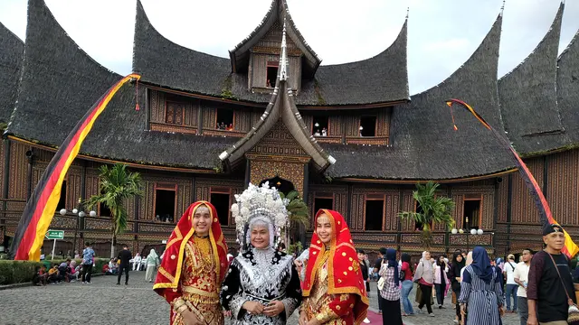 Pengunjung Istana Pagaruyung mengenakan pakaian adat Minangkabau yang bisa di sewa di objek wisata itu. (Liputan6.com/ Novia Harlina)