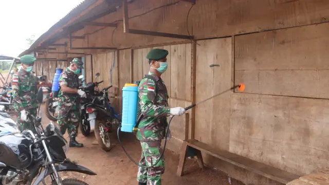 Aparat TNI-Polri mencegah penyebaran virus corona Covid-19 di perbatasan RI dengan menyemprot cairan disinfektan