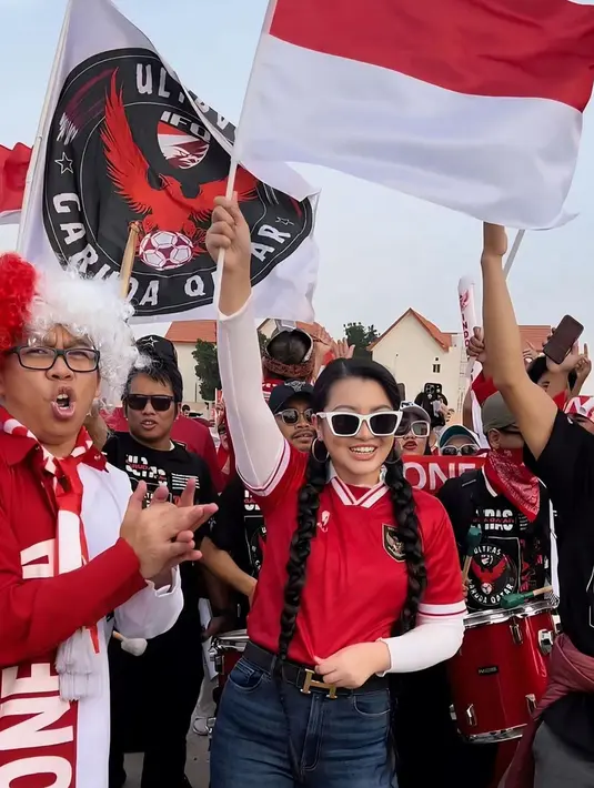 Tak hanya menonton langsung, Fitri Carlina bahkan ikut bergabung dengan Indonesian Football Asociation in Qatar sebagai suporter. Fitri pun terlihat ikut berjalan sembari membawa bendera Indonesia di sekitar Stadion Jassim bin Hamad. (Liputan6.com/IG/@fitricarlina)