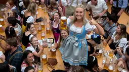 Seorang wanita menunjukkan gelas berisi bir bersama rekan-rekannya saat mengikuti festival minum bir tahunan dalam pembukaan Oktoberfest ke-182 di Munich, Jerman (16/9). (AFP Photo/dpa/Sven Hoppe/Germany Out)