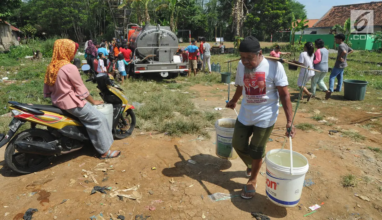 Warga membawa air bersih bantuan Badan Penanggulangan Bencana Daerah (BPPD) Kabupaten Bogor di Pabuaran, Ciampea, Bogor, Jawa Barat, Senin (6/8). BPPD Kabupaten Bogor mengerahkan lima truk tangki air bersih setiap hari. (Merdeka.com/Arie Basuki)