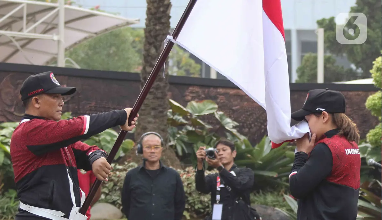 Atlet berbagai cabang olahraga mencium bendera merah putih ketika mengikuti pengukuhan dan pelepasan kontingen Indonesia untuk SEA Games ke-32 Kamboja di Lapangan Kementerian Pemuda dan Olahraga (Kemenpora), Jakarta, Selasa (2/5/2023). (Liputan6.com/Herman Zakharia)