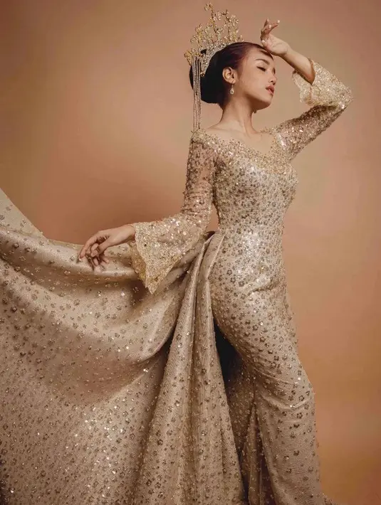 Gaun pengantin berwarna emas dari Laviena Wedding Gallery tersebut dihiasi payet emas yang mewah. Instagram/fuji_an/laviennawedingallery.