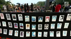 Aktivis menunjukkan foto para korban HAM saat aksi Kamisan ke-502 di seberang Istana Merdeka, Jakarta, Kamis (10/8). Aksi meminta pemerintah mewujudkan komitmen dalam menyelesaikan kasus pelanggaran HAM berat pada masa lalu. (Liputan6.com/Johan Tallo)