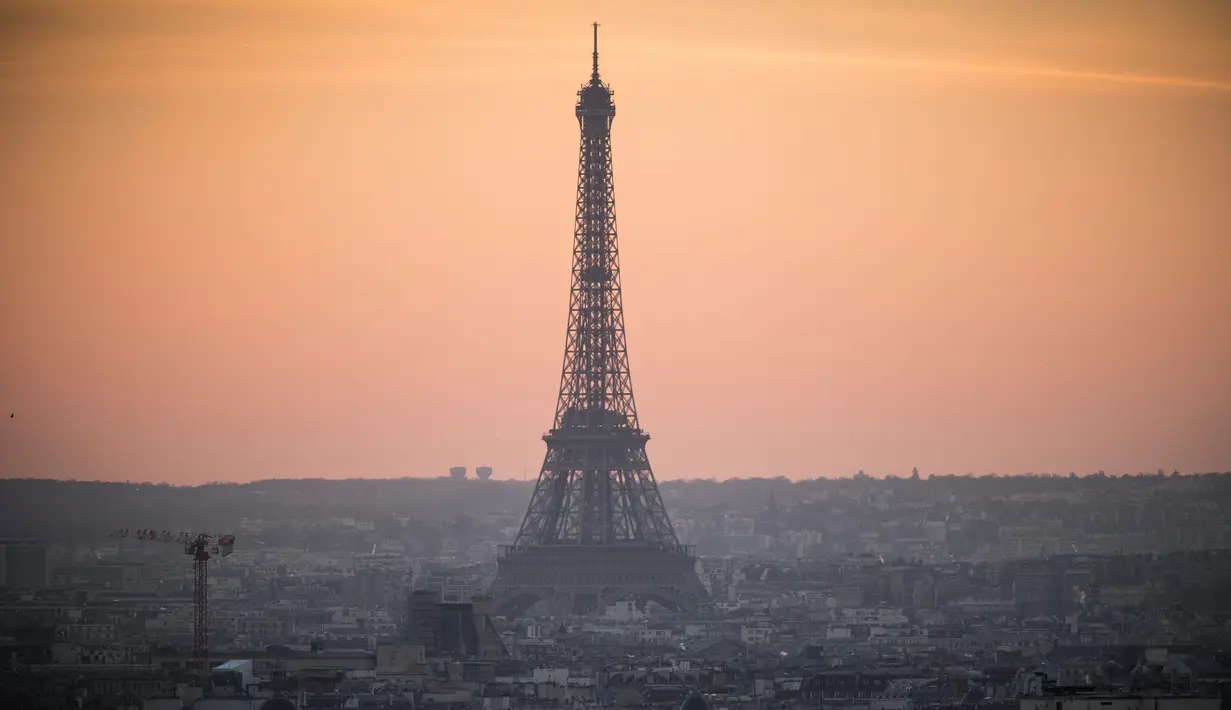 Pemandangan Menara Eiffel yang diselimuti kabut polusi, Paris, Prancis (3/12). Sebelumnya, Prancis menerapkan aturan mengurangi jumlah mobil dengan cara menyiapkan kendaraan transit umum gratis guna menekan polusi udara. (AFP/Lionel Bonaventure)