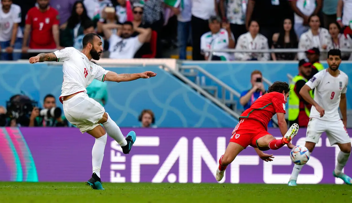 Pemain Iran Rouzbeh Cheshmi menendang bola untuk mencetak gol ke gawang Wales pada pertandingan sepak bola Grup B Piala Dunia 2022 di Stadion Ahmad Bin Ali, Al Rayyan, Qatar, Jumat (25/11/2022). Iran mengalahkan Wales dengan skor 2-0. (AP Photo/Frank Augstein)