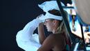 Petenis Ukraina Marta Kostyuk meletakkan es di kepalanya untuk mendinginkan diri saat bermain melawan petenis Spanyol Paula Badosa pada pertandingan tunggal putri turnamen tenis Australian Open di Melbourne, Australia, 21 Januari 2022. (William WEST/AFP)