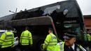 Polisi menjaga ketat bus Manchester United yang beberapa bagian kacanya pecah setelah dilempar oleh oknum suporter West Ham United. Rabu (11/5/2016) dini hari WIB. (AFP/Glyn Kirk)