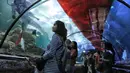 Pengunjung mengamati penyelam membentangkan bendera Merah Putih untuk memperingati HUT Ke-73 RI di Seaworld Ancol, Jakarta, Jumat (17/8). Pengibaran bendera melibatkan para penyelam profesional dan artis peran Marsha Aruan. (Liputan6.com/Faizal Fanani)