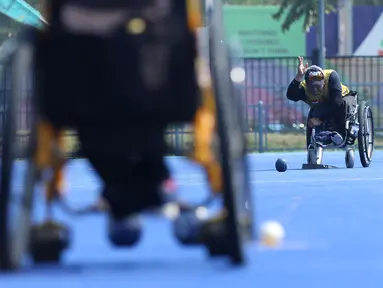 Atlet Para Games Indonesia cabang olahraga Lawn Bowls melakukan lemparan saat latihan di Lapangan Hoki Kompleks GBK, Jakarta, Selasa (18/9). Latihan ini adaptasi lapangan sekaligus persiapan jelang Asian Para Games 2018. (Liputan6.com/Helmi Fithriansyah)