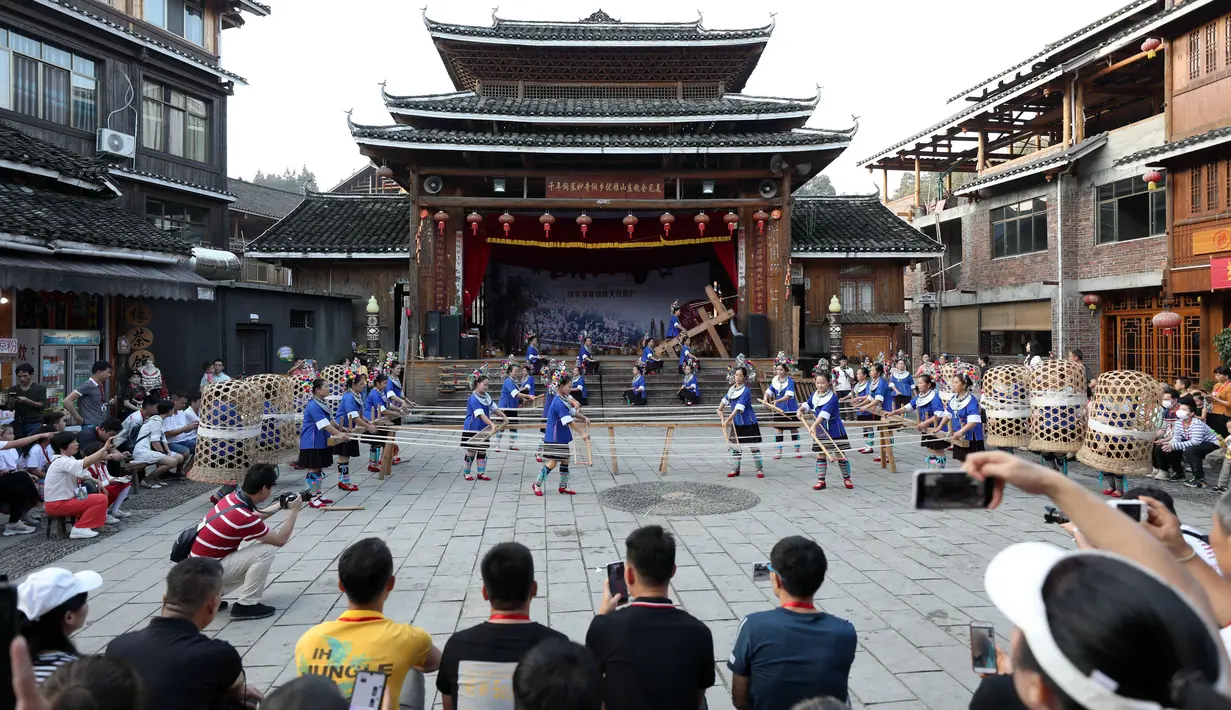 Wisatawan menyaksikan pertunjukan di sebuah kawasan wisata di Wilayah Otonom Etnis Dong Sanjiang di Kota Liuzhou, China, 2 Oktober 2020. Sejak jalur kereta cepat Guiyang-Guangzhou beroperasi pada 2014, Sanjiang telah berupaya untuk meningkatkan perekonomian melalui pariwisata. (Xinhua/Gong Pukang)
