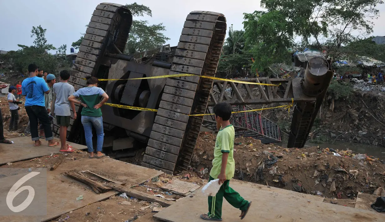 Warga melihat Crane yang jatuh ke Sungai Ciliwung Kelurahan Bukit Duri, Jakarta Selatan  (1/10/15). Akibatnya seorang warga RT15/10 Kelurahan Bukit Duri, Jakarta Selatan harus mendapatkan perawatan medis. (Liputan6.com/Gempur M Surya)